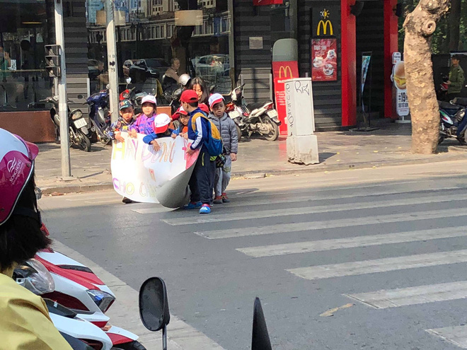 Các bé mẫu giáo cầm tờ giấy đi sang đường, dòng chữ bên trên khiến người lớn chột dạ-2