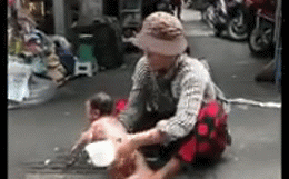 Phẫn nộ cảnh người phụ nữ ngồi giữa đường, dội nước vào đứa trẻ còn đỏ hỏn-1