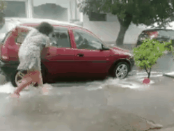CLIP: Tiết kiệm nước, người phụ nữ tranh thủ rửa xe dưới... trời mưa