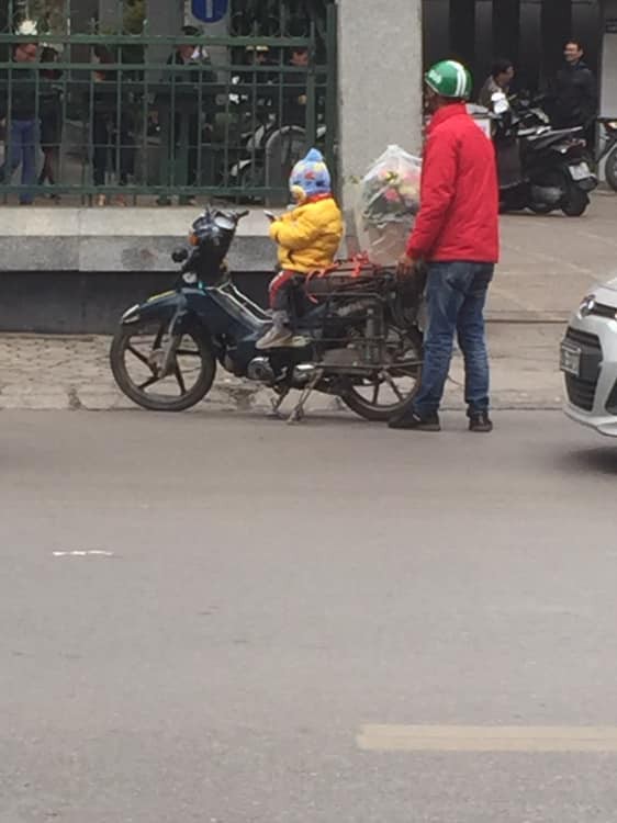 Hình ảnh cháu bé ngồi ngoan trên xe máy giữa cái se lạnh chờ đợi cha đi ship hoa tươi trong ngày 8/3 gây xúc động-2