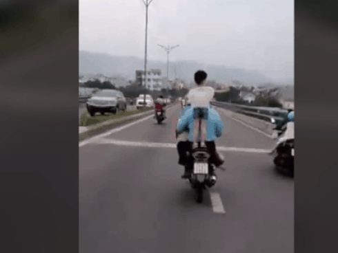 Để con đứng lên yên xe đầu không đội nón bảo hiểm, người cha vẫn chạy xe vèo vèo trên đường gây bức xúc