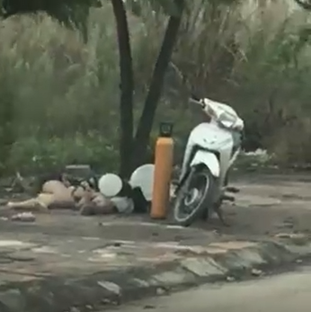 Clip: Đôi nam nữ vô tư dựng xe máy, nằm vạ vật hút bóng cười trên vỉa hè-1