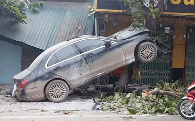Ô tô Mercedes mất lái trèo lên cây bàng, người dân giải cứu tài xế đưa đi cấp cứu-1