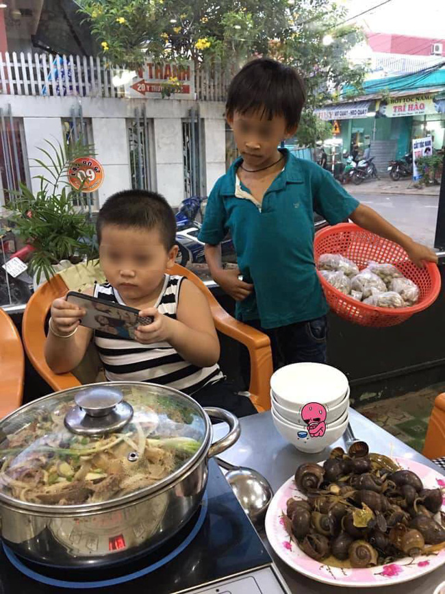 1 bức ảnh, 2 số phận: Hình ảnh cậu bé bán hàng rong lặng lẽ xem ké điện thoại của người bạn cùng tuổi bên bàn lẩu khiến nhiều người xót xa-1