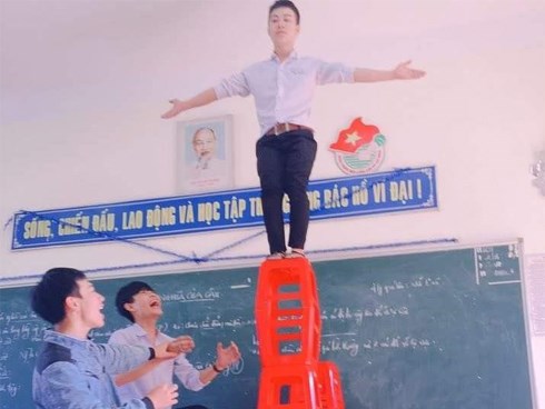 Ảnh nam sinh tạo dáng nguy hiểm trên hàng ghế cao gây tranh cãi