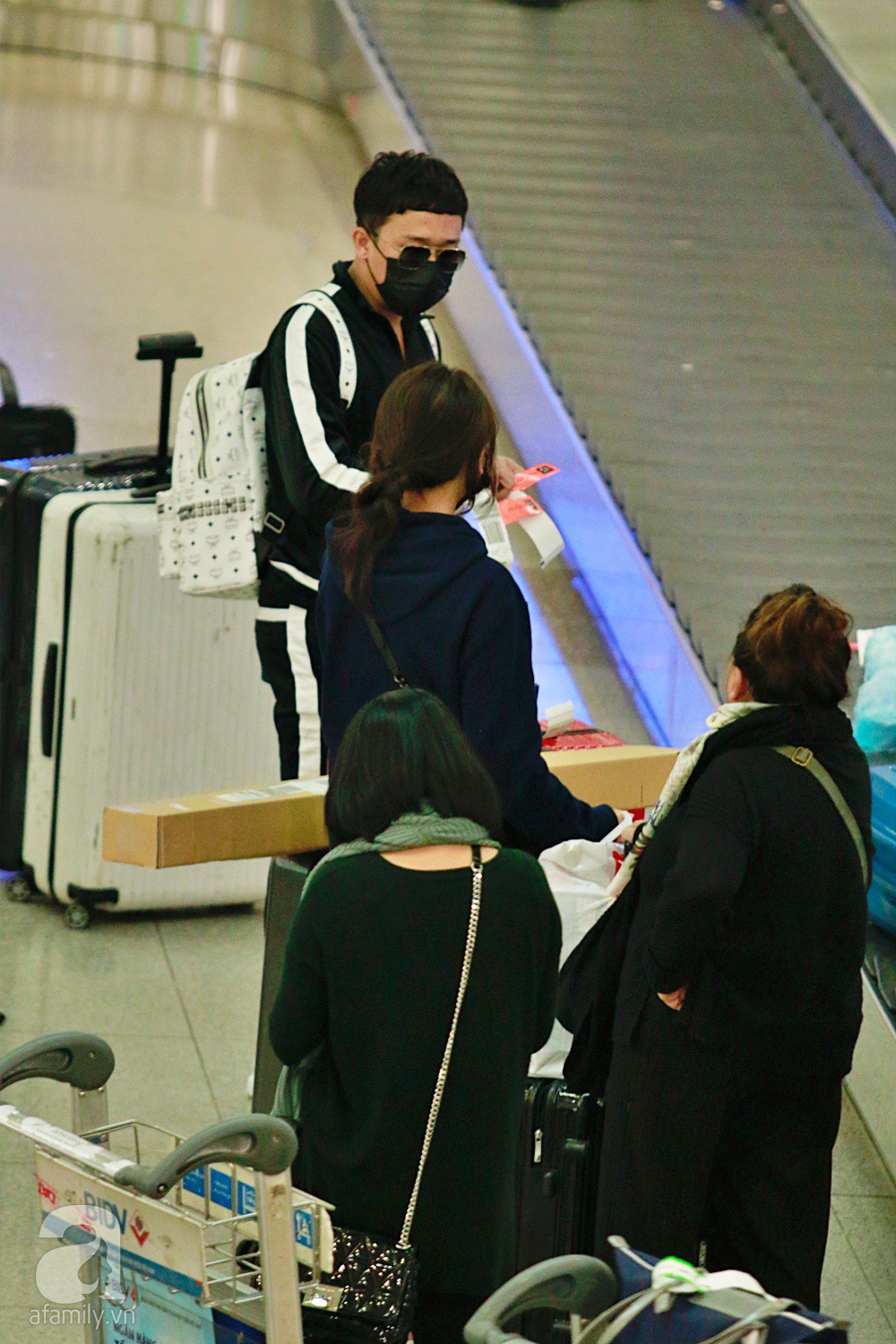 Vợ chồng Trấn Thành - Hari Won đeo khẩu trang kín mít xuất hiện tại sân bay lúc đêm muộn-5