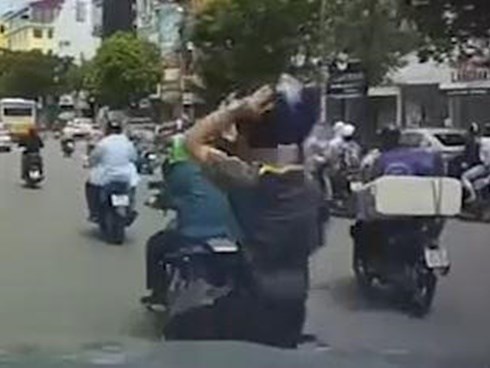 Bị ép vào ôtô, thanh niên lấy mũ bảo hiểm ném vào xe máy