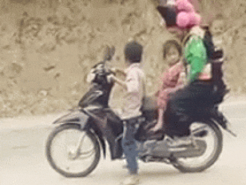CLIP: Ngồi xe máy chân không chạm đất, cậu bé vẫn cầm lái đèo 3 người phía sau
