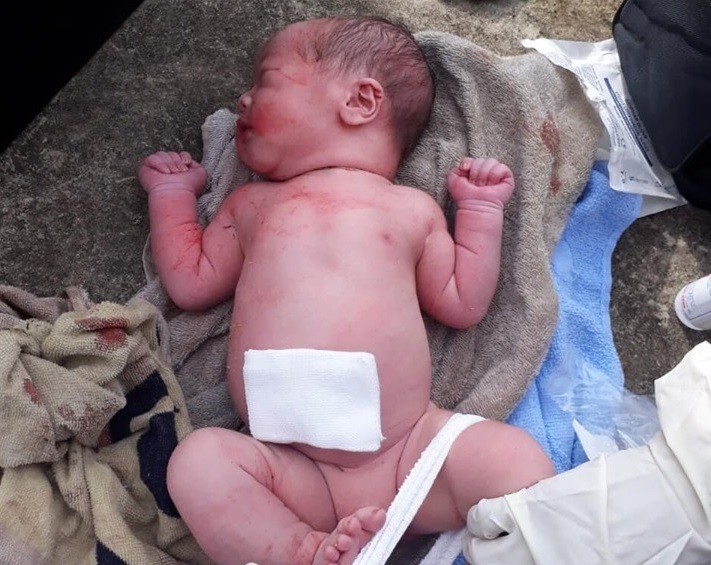 Phát hiện bé trai sơ sinh người còn dính máu bị mẹ bỏ rơi trong bụi hoa giấy ven đường-1