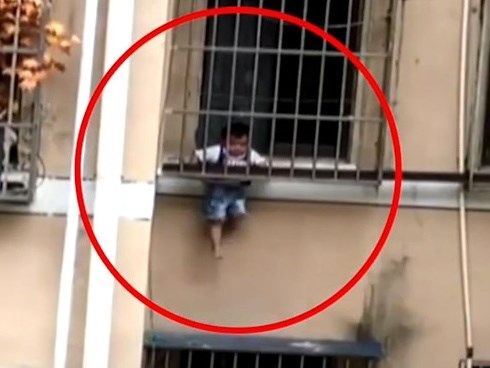 Bé trai ở nhà một mình lủng lẳng giữa các song sắt cửa sổ tầng 3