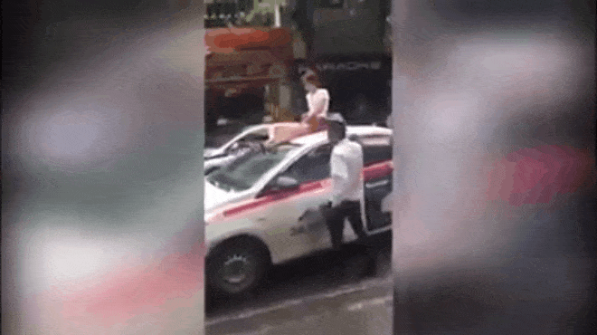 Cô gái làm loạn trên nóc taxi bị đuổi xuống, tài xế vừa tăng ga lại đuổi theo gây sự-1