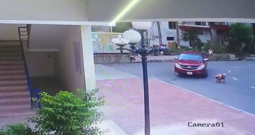 Bé trai chơi dưới lòng đường bị cuốn vào gầm xe bán tải, người dân phải nâng đầu xe để giải cứu cháu bé-2