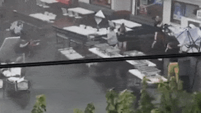 Vừa hay tin cuồng phong bão tố kéo đến, 2 nhân viên nhà hàng trở tay không kịp bị cuốn bay lên không trung 6m, tạo nên cảnh tượng như phim-1