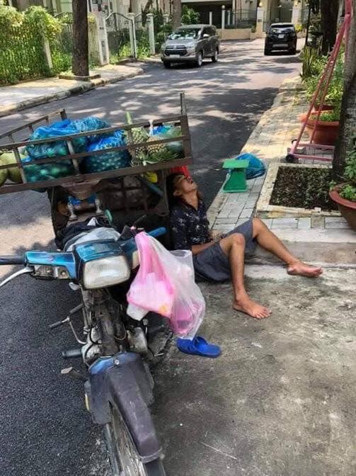 Anh bán hoa quả ngủ gục bên lề đường, tay vẫn cầm xấp tiền lẻ khiến nhiều người xót xa-1