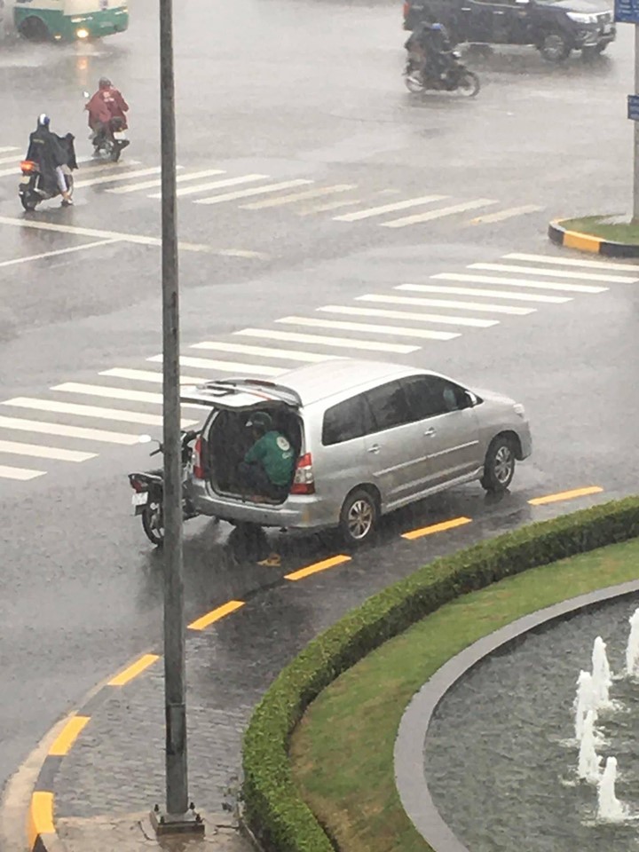 Ô tô 7 chỗ dừng bên góc đường, mở cửa để tài xế xe ôm kịp ngồi trú mưa khiến nhiều người cảm thấy ấm lòng-1