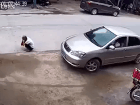 CLIP: Cụ ông ngồi xổm trước mũi ô tô bất ngờ gặp 