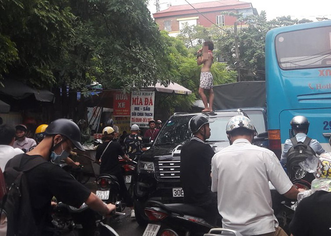 Xôn xao hình ảnh cô gái không mặc áo trèo trên nóc ô tô la hét khiến người đi đường hoảng sợ-1