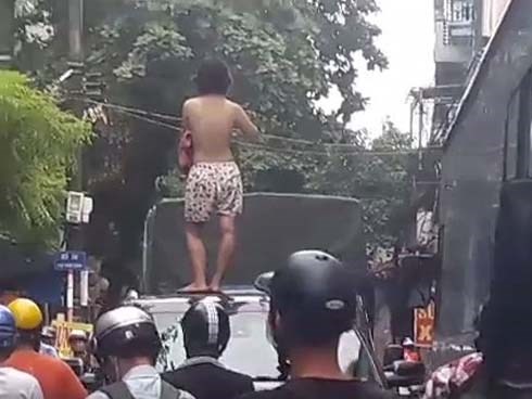 Xôn xao hình ảnh cô gái không mặc áo trèo trên nóc ô tô la hét khiến người đi đường hoảng sợ