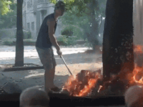 Người đàn ông đốt rác ngay gốc cây