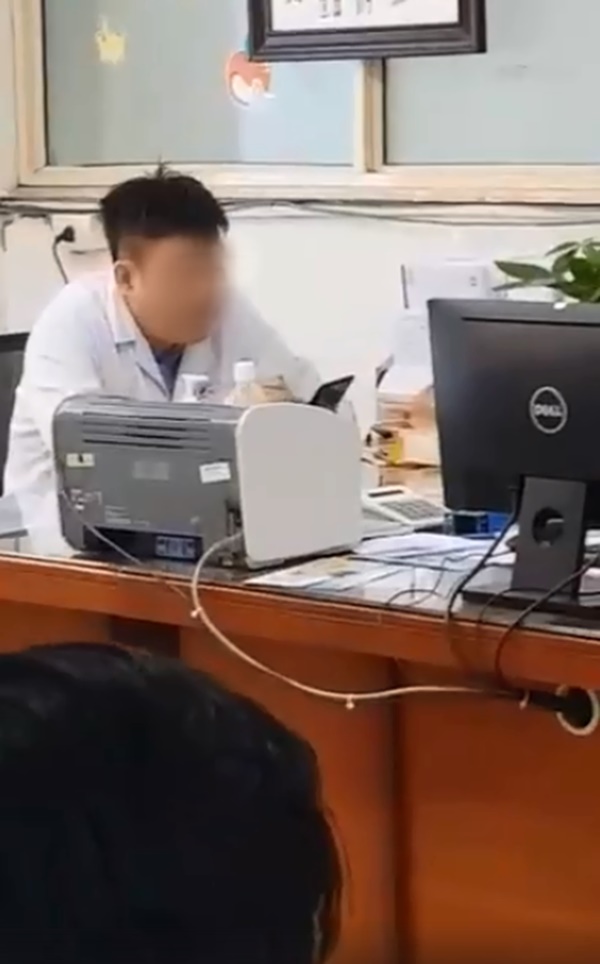 Xôn xao hình ảnh bác sĩ ngồi thản nhiên xem điện thoại dù bệnh nhân xếp hàng dài chờ đợi trong giờ hành chính-1