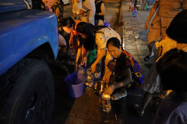 Chùm ảnh: Người dân Hà Nội rồng rắn xếp hàng giữa đêm, mang theo xô chậu đợi lấy nước sạch miễn phí-16