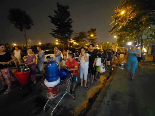 Chùm ảnh: Người dân Hà Nội rồng rắn xếp hàng giữa đêm, mang theo xô chậu đợi lấy nước sạch miễn phí-4