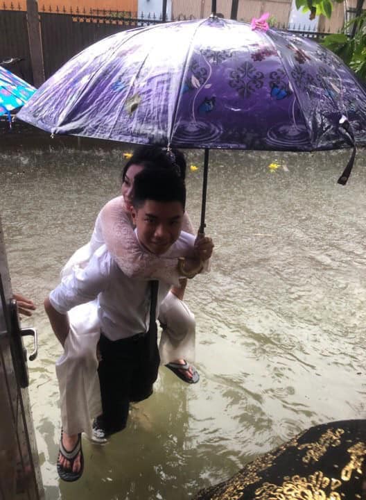 Em gái mưa phiên bản lũ lụt: Câu chuyện đằng sau bức ảnh chú rể cõng cô dâu đứng giữa biển nước đang nổi rần rần MXH-1