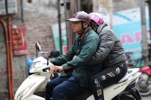 Không khí lạnh tràn về, nhiệt độ giảm mạnh, người dân thích thú mặc áo ấm ra đường dưới trời mưa phùn-1