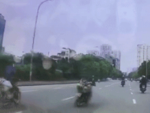Người phụ nữ vắt chéo chân, lạng lách khi đi xe máy trên phố-1
