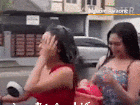 Hai cô gái vừa đi xe máy vừa gội đầu trên đường
