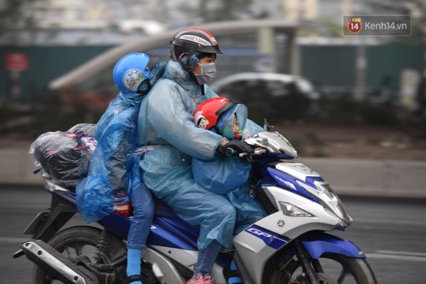 Trẻ nhỏ trùm chăn, khoác áo mưa chật vật theo chân bố mẹ rời Thủ đô về quê ăn Tết-1