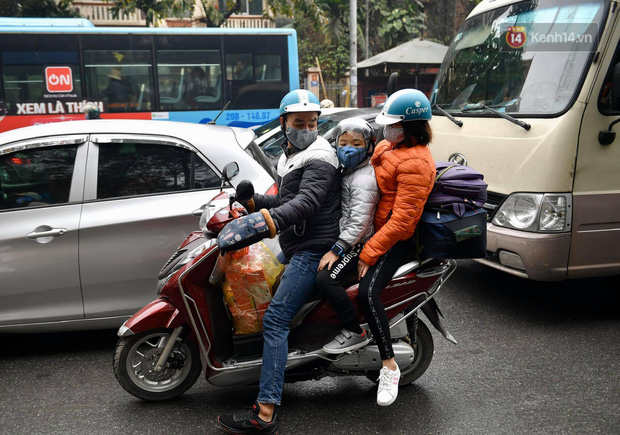 Trẻ nhỏ trùm chăn, khoác áo mưa chật vật theo chân bố mẹ rời Thủ đô về quê ăn Tết-4