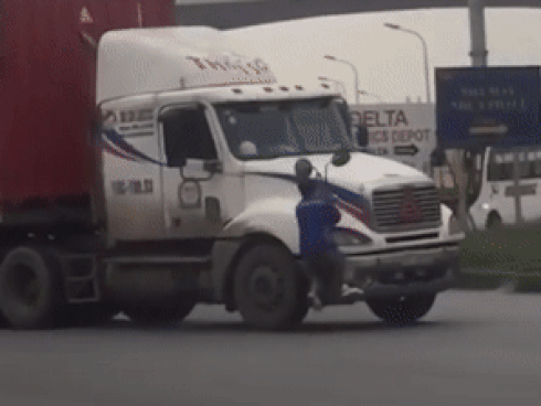 Người đàn ông bám lên gương container đang chạy