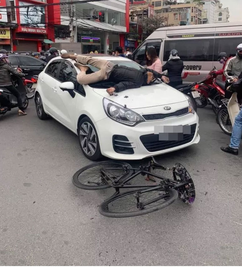Va chạm giao thông không hòa giải được, chủ xe đạp leo lên nắp capo ô tô nằm-1