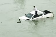 Hình ảnh tài xế trèo lên nóc xe ô tô trôi lềnh bềnh giữa sông khiến nhiều người hoang mang