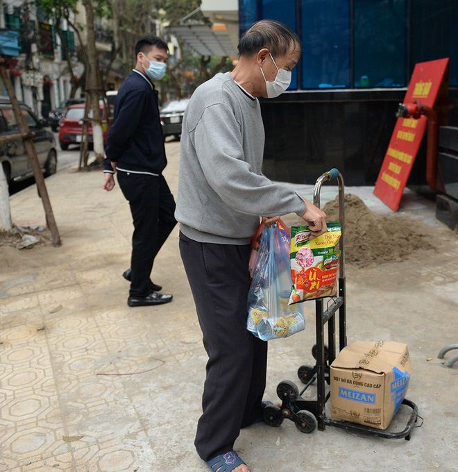 Người dân sống trong khu cách ly trên phố Trúc Bạch mang xe đẩy nhận nhu yếu phẩm-6