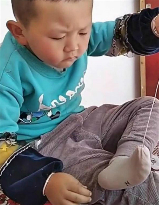 Cậu bé gây chú ý bởi hành động ngồi khâu chiếc tất bị rách, biểu cảm đáng yêu khiến ai cũng thả tim rầm rầm-1