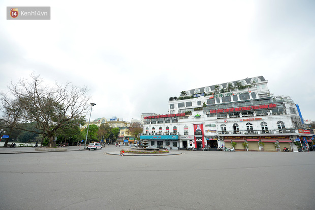 Khung cảnh khác lạ của Hà Nội thời dịch Covid-19: Những cánh cửa im phăng phắc, người dân trùm kín tập thể dục bên hồ Gươm-1