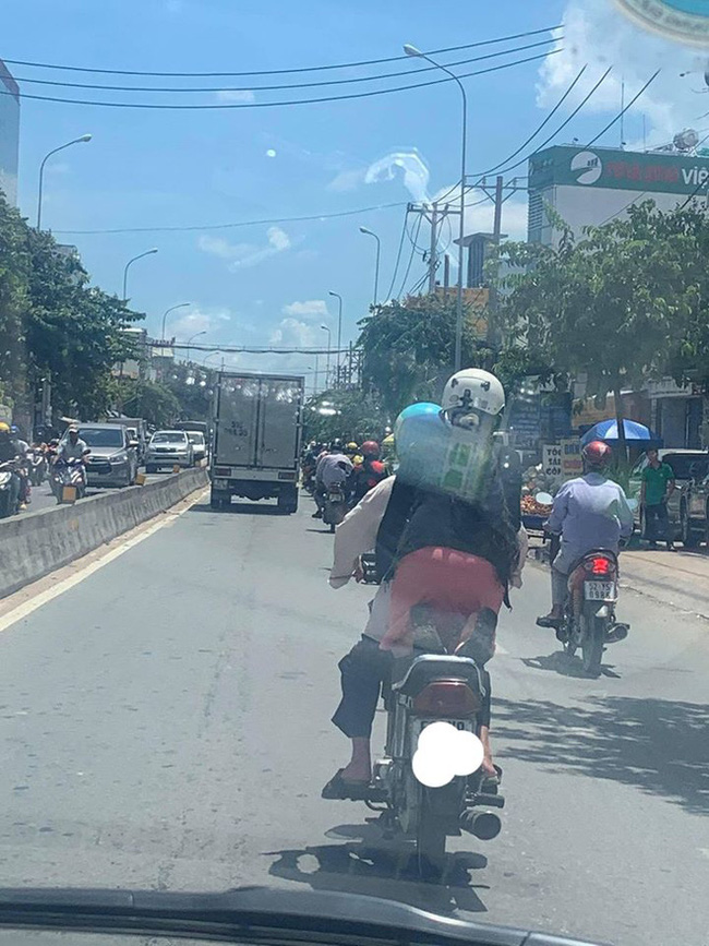 Đi xe máy dưới trời nắng cháy da, người phụ nữ có dáng ngồi khiến tất cả đều ngoái nhìn khó hiểu-1