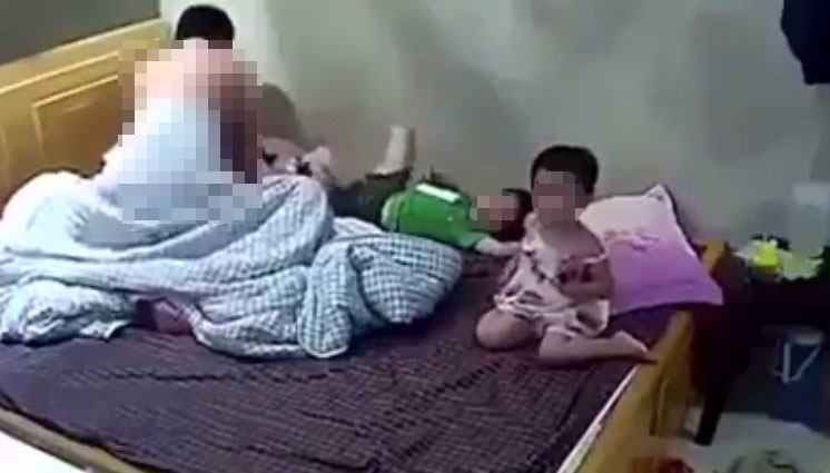 Clip phản cảm: Bật tivi cho 2 con xem, vợ chồng che chăn thản nhiên làm chuyện ấy ngay trước mặt con trẻ-1