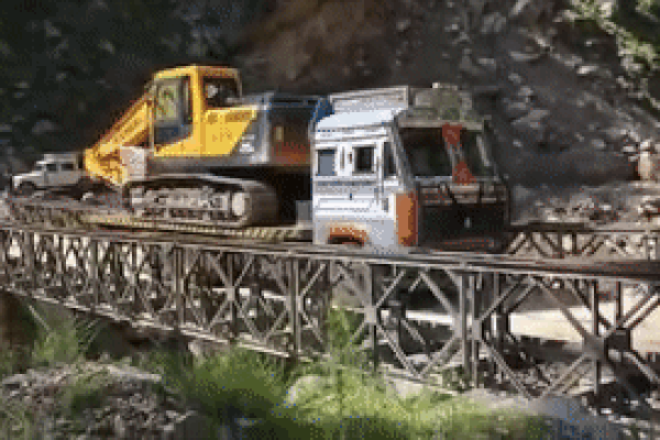 Cầu sắt đổ sập, xe tải và xe máy xúc rơi xuống vực