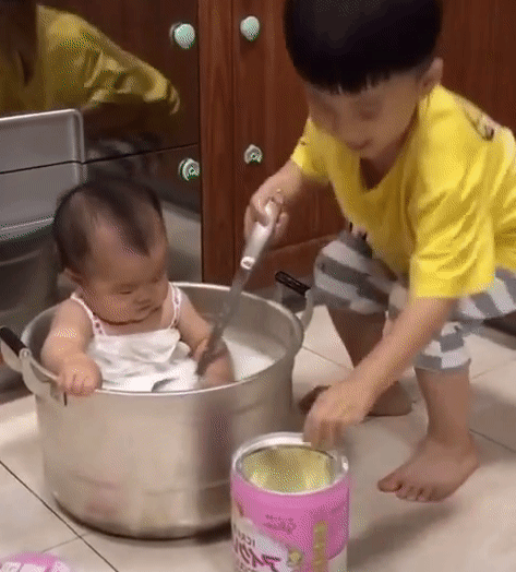 Nghe lời bố mẹ ở nhà pha sữa cho em gái uống, nhìn cách anh trai thực hiện mà bố mẹ chỉ còn biết câm nín