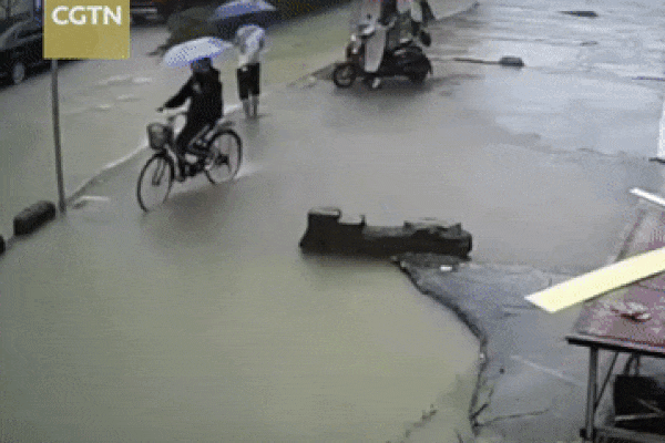 Khoảnh khắc hố nước sâu bất ngờ ‘nuốt chửng’ cặp vợ chồng đi xe máy-1
