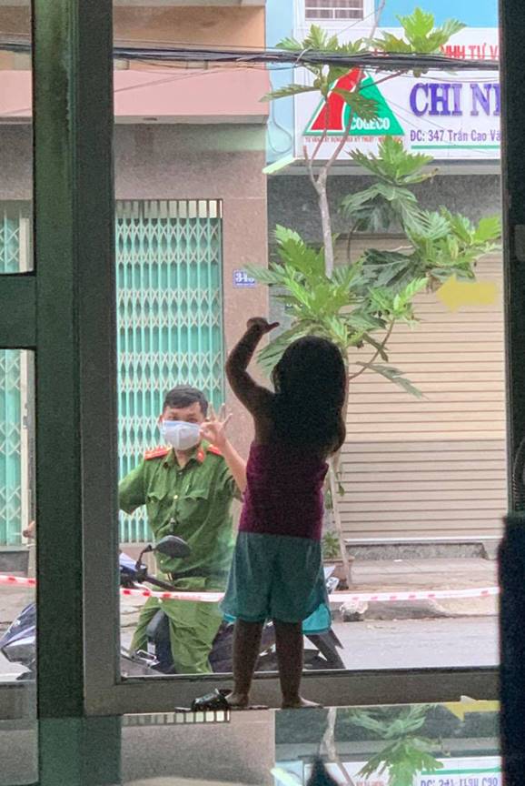 Hình ảnh chiến sĩ công an vùng tâm dịch Đà Nẵng đi qua nhà, vẫy chào con gái qua khung cửa kính gây xúc động-1