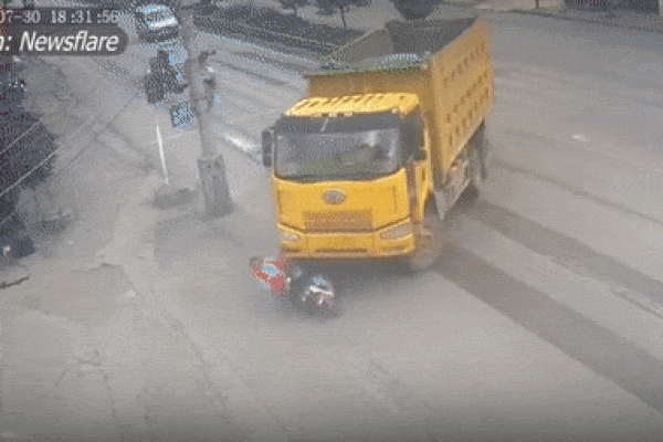 Bị xe tải ‘nuốt chửng’, người phụ nữ đi xe điện thoát chết kỳ diệu