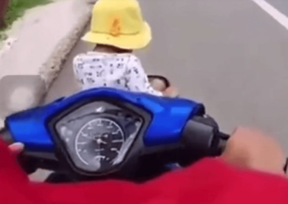 Clip: Để con ngồi vắt vẻo trước giỏ xe máy, bố mẹ vẫn thản nhiên chạy vèo vèo trên đường-1