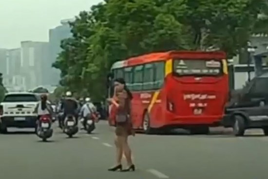 Người phụ nữ mải nhìn điện thoại khi băng qua đường