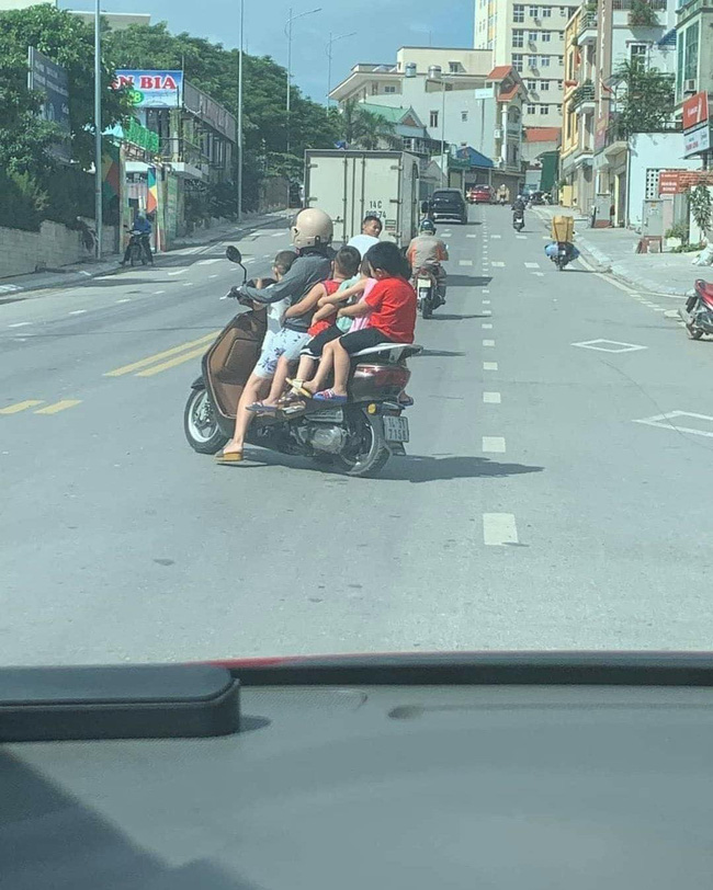 Thót tim hình ảnh người phụ nữ liều lĩnh để 5 em nhỏ không đội mũ bảo hiểm ngồi vắt vẻo, chật ních chiếc xe gắn máy-1