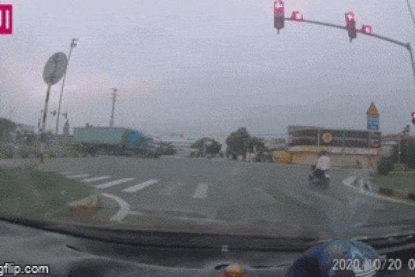 Xe máy vượt đèn đỏ đâm vào xe container