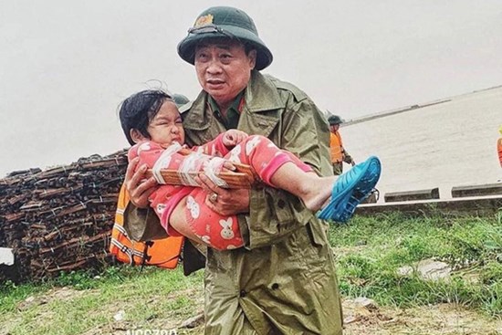 Khoảnh khắc chiến sĩ công an bế bé gái gãy tay vội vã lên ô tô tới bệnh viện trong cơn mưa lũ Quảng Bình gây xúc động